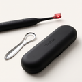 OralLux travel case and stainless steel tongue scraper with the toothbrush behind