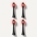 Four matte black OralLux replacement brush heads with red LED bristle fields, arranged in a grid